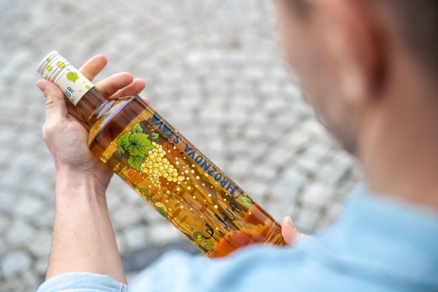 Fľaša hroznového nápoja v ruke.