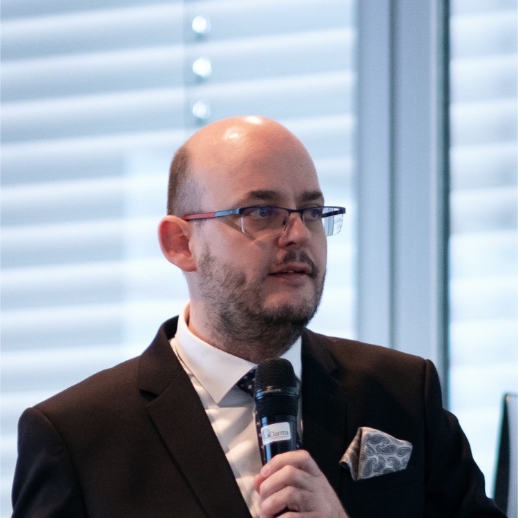 Muž v obleku hovorí na podujatí.